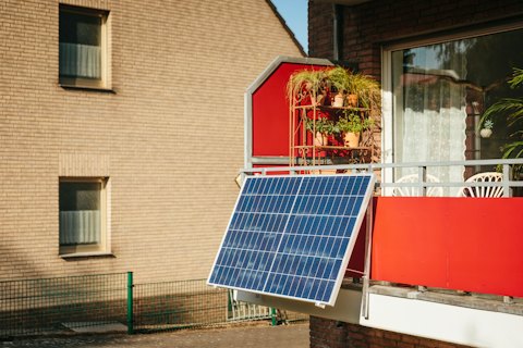 Solar panel mounted on a balcony with plants