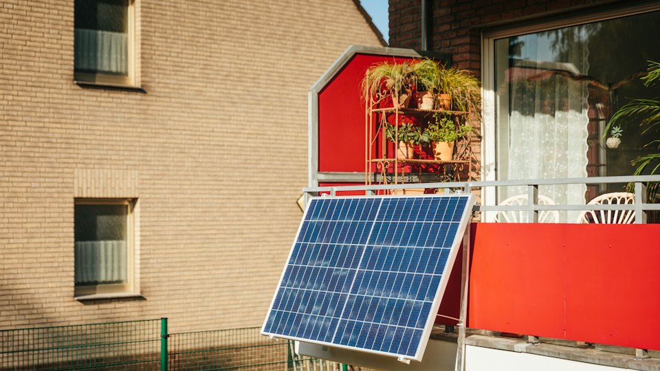 Solar panel mounted on a balcony with plants