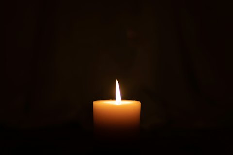 A lit candle in a dark room