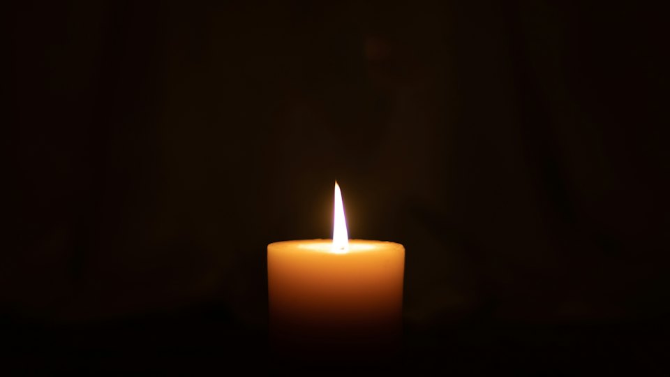 A lit candle in a dark room