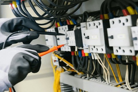 Electrician testing a consumer unit with a multimeter
