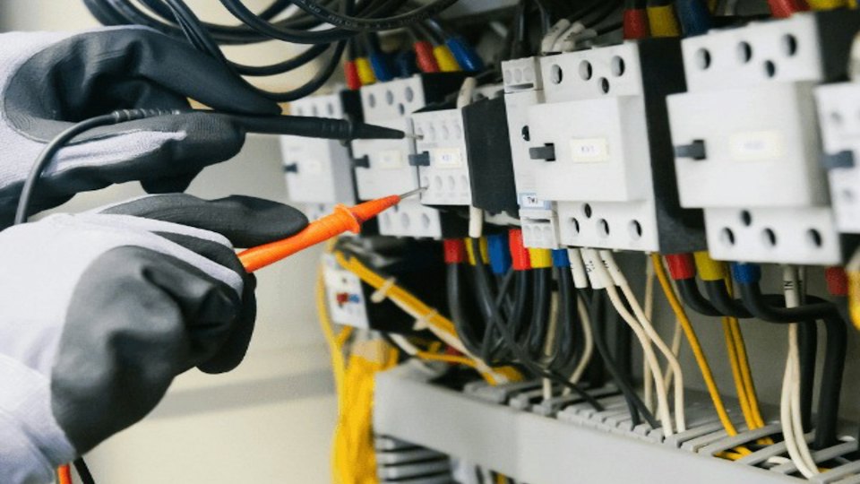 Electrician testing a consumer unit with a multimeter